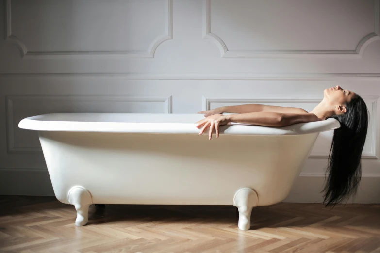 a woman laying upside down in a tub