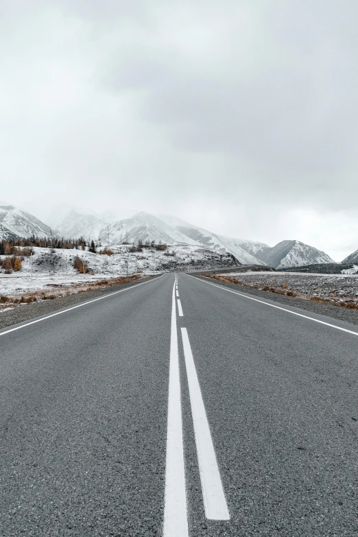 a road and a snow covered mountain side