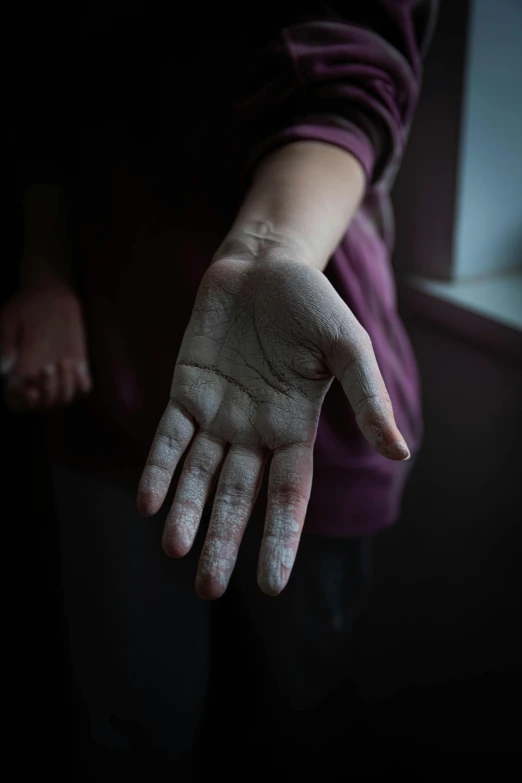 a person wearing a purple shirt holding their hand in their left palm