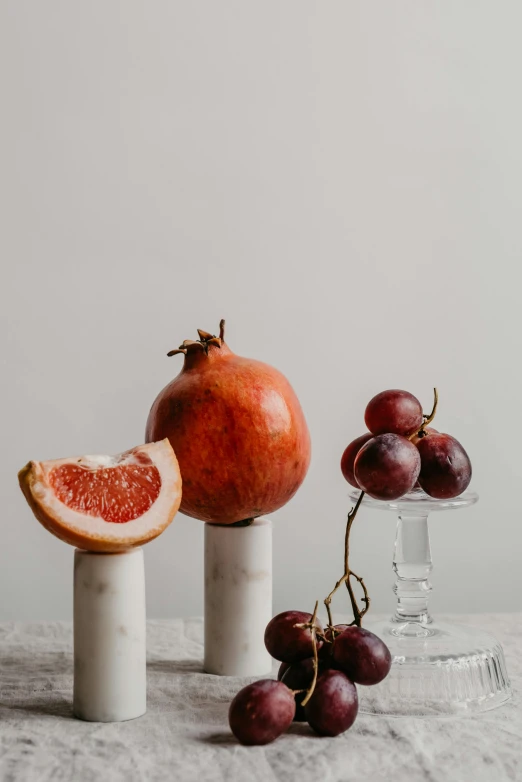 a red gfruit on a marble pedestal with other items and gs