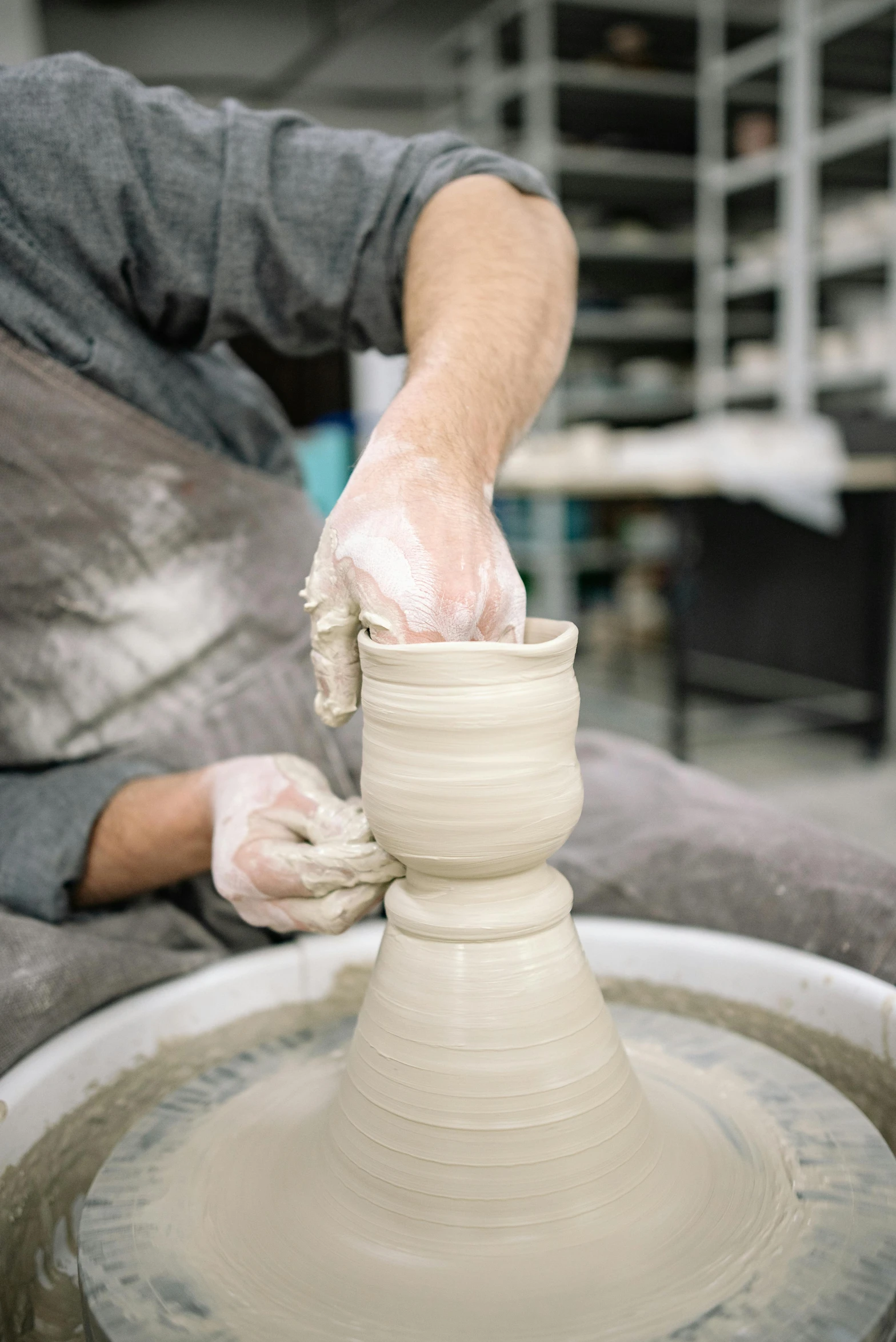 the potter has thrown a pot on a potter wheel
