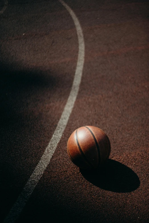 a basketball ball laying on a tennis court