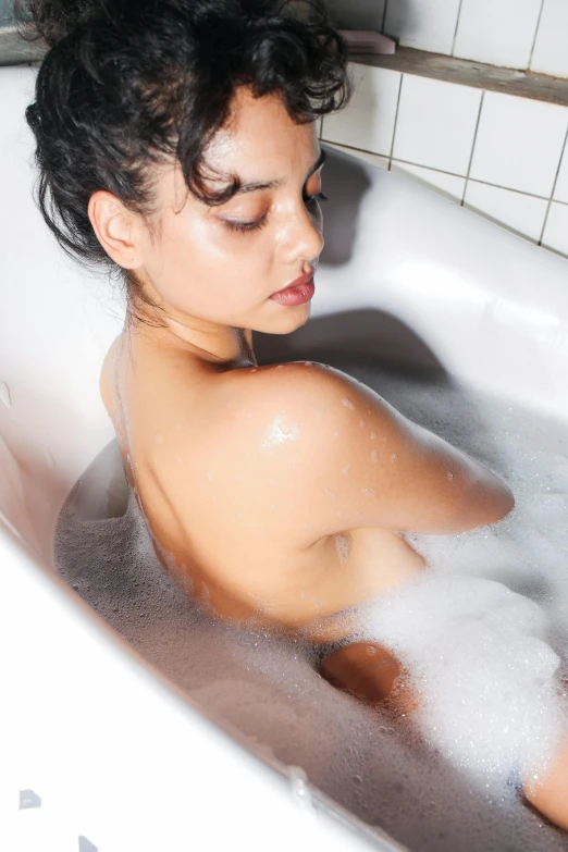 a woman relaxing in the bathtub with her eyes closed