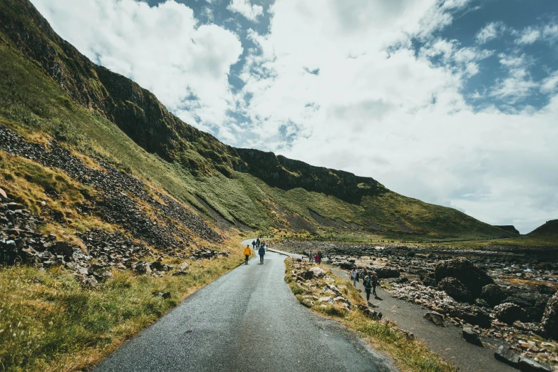 two people walking down a mountain side trail