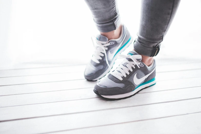 a woman's legs in blue and grey sneakers