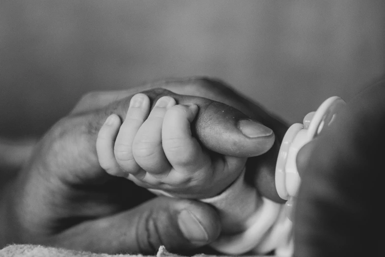 two hands hold a bottle filled with cream on top of a blanket