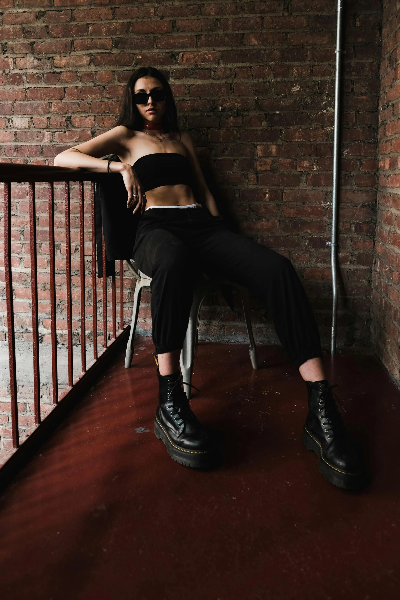 a woman is posing for a po in front of a brick wall