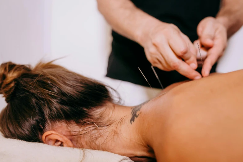 a woman getting her face examined by a woman with scissors