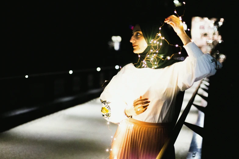 a woman with her arms in the air standing outside