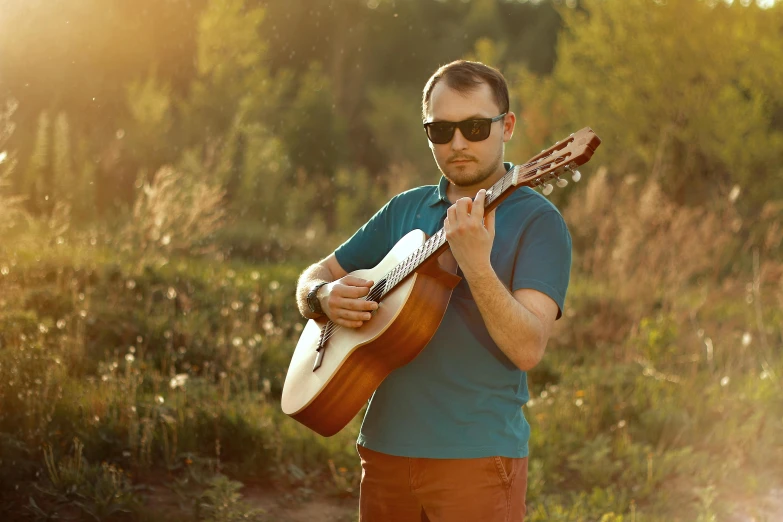 a man with sunglasses on playing the guitar