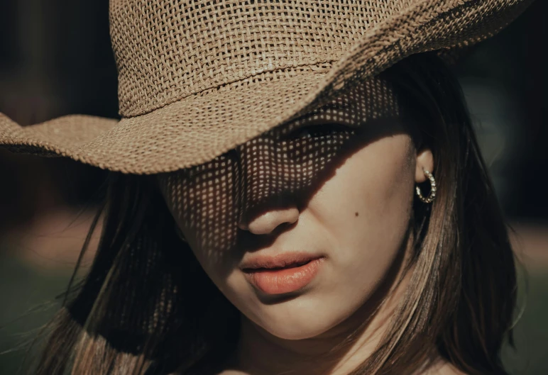 a close up of a girl wearing a brown hat