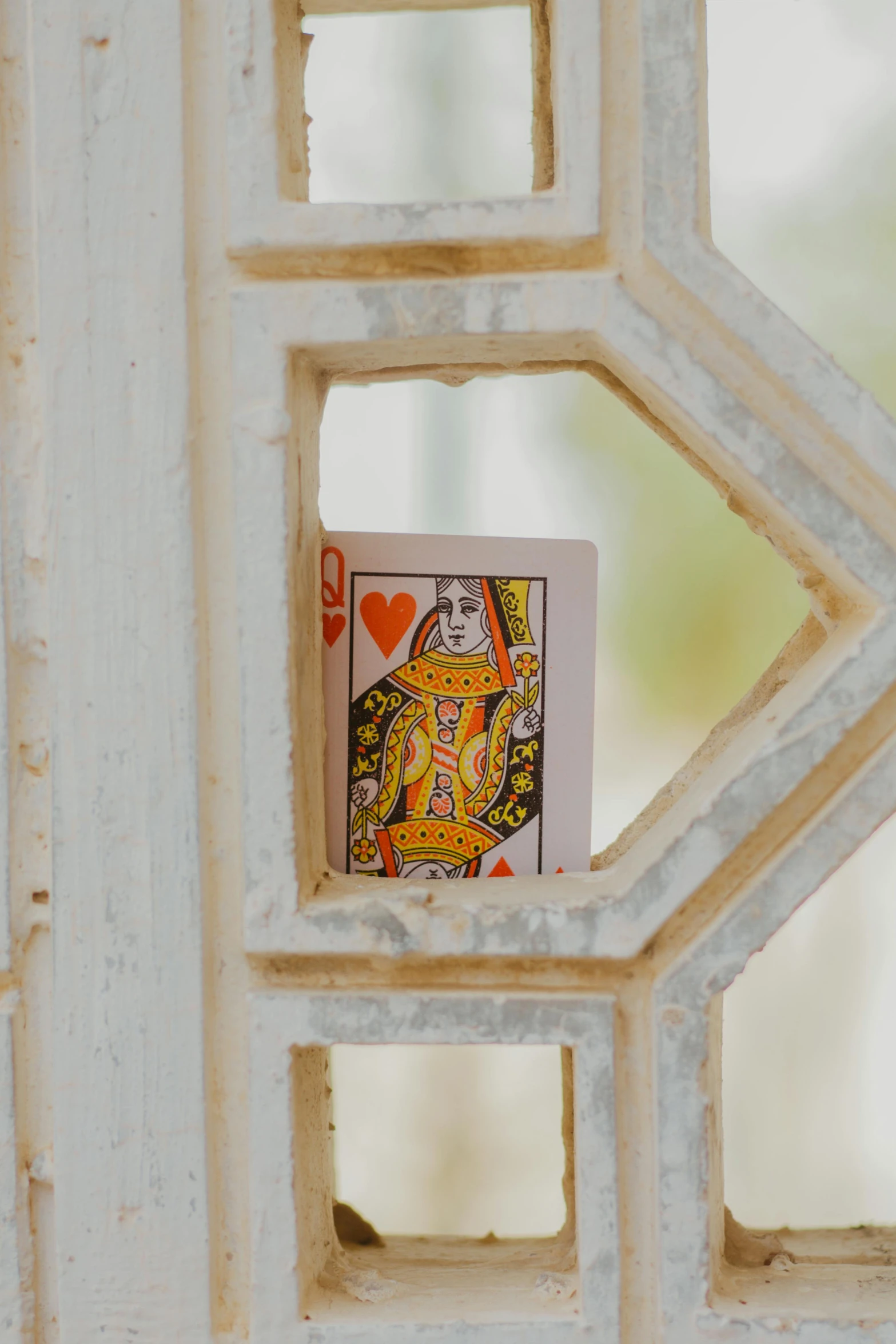 a playing card stuck into a hole in a white painted woodwork