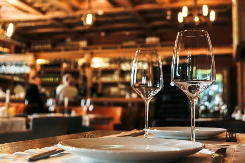 two glasses of wine sitting next to each other on top of a table