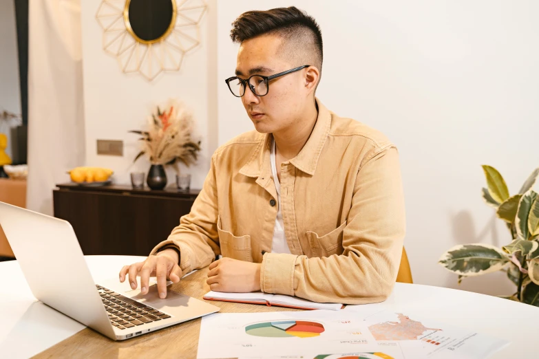 man using a laptop computer at a wooden table