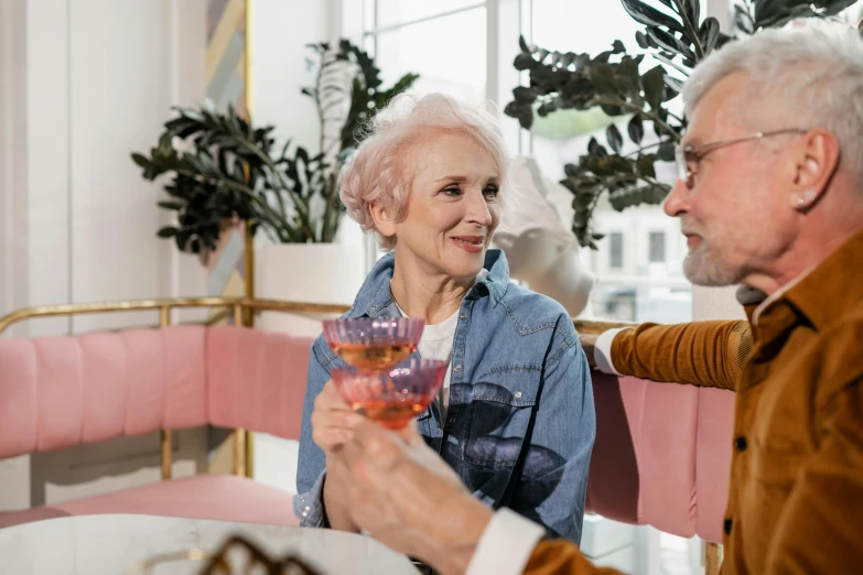 an older woman and old man enjoying drinks