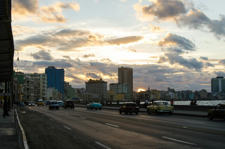 city street scene with cars driving under a cloudy sky