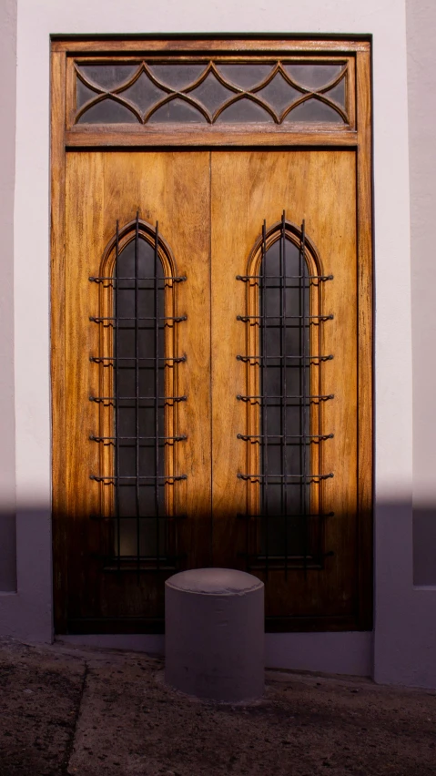 the side of a building with wooden doors and round table