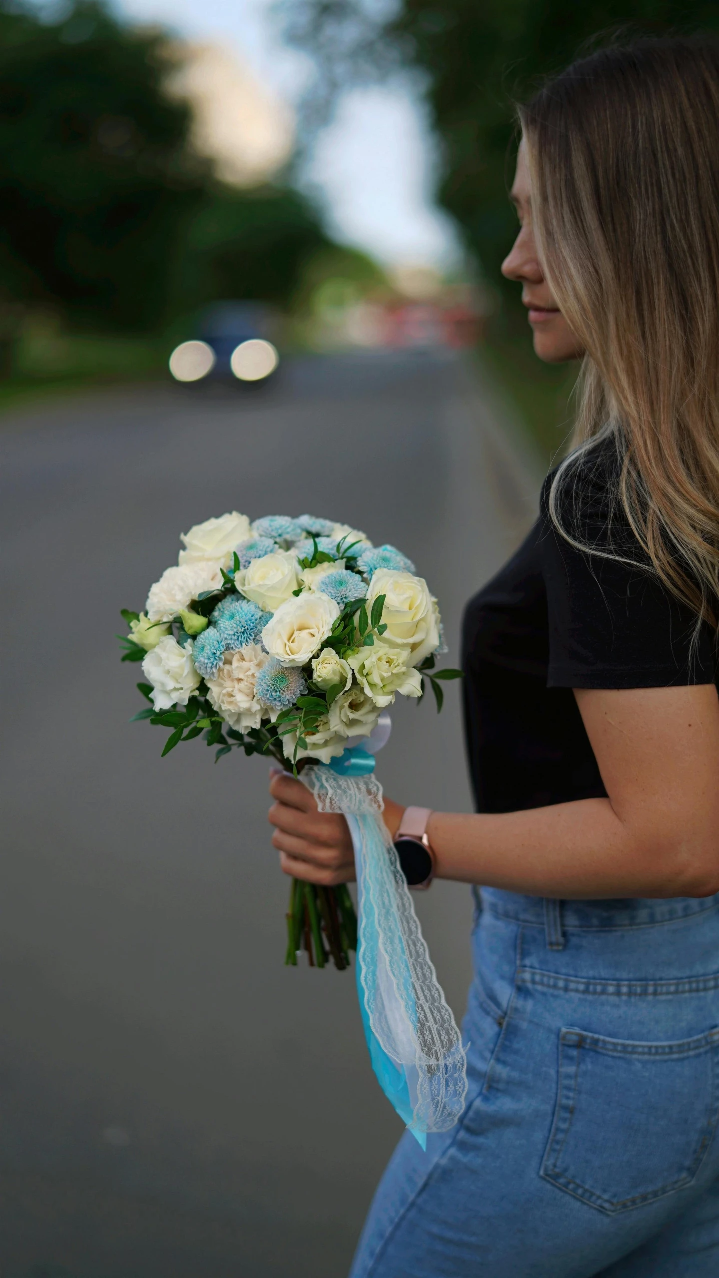 a beautiful woman in blue overalls and holding a bouquet of flowers