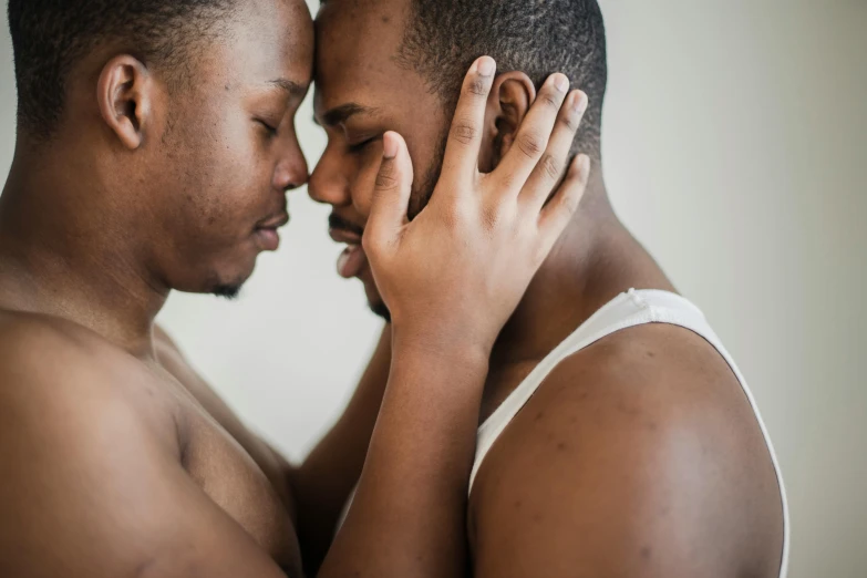 two black men touching their faces with one another