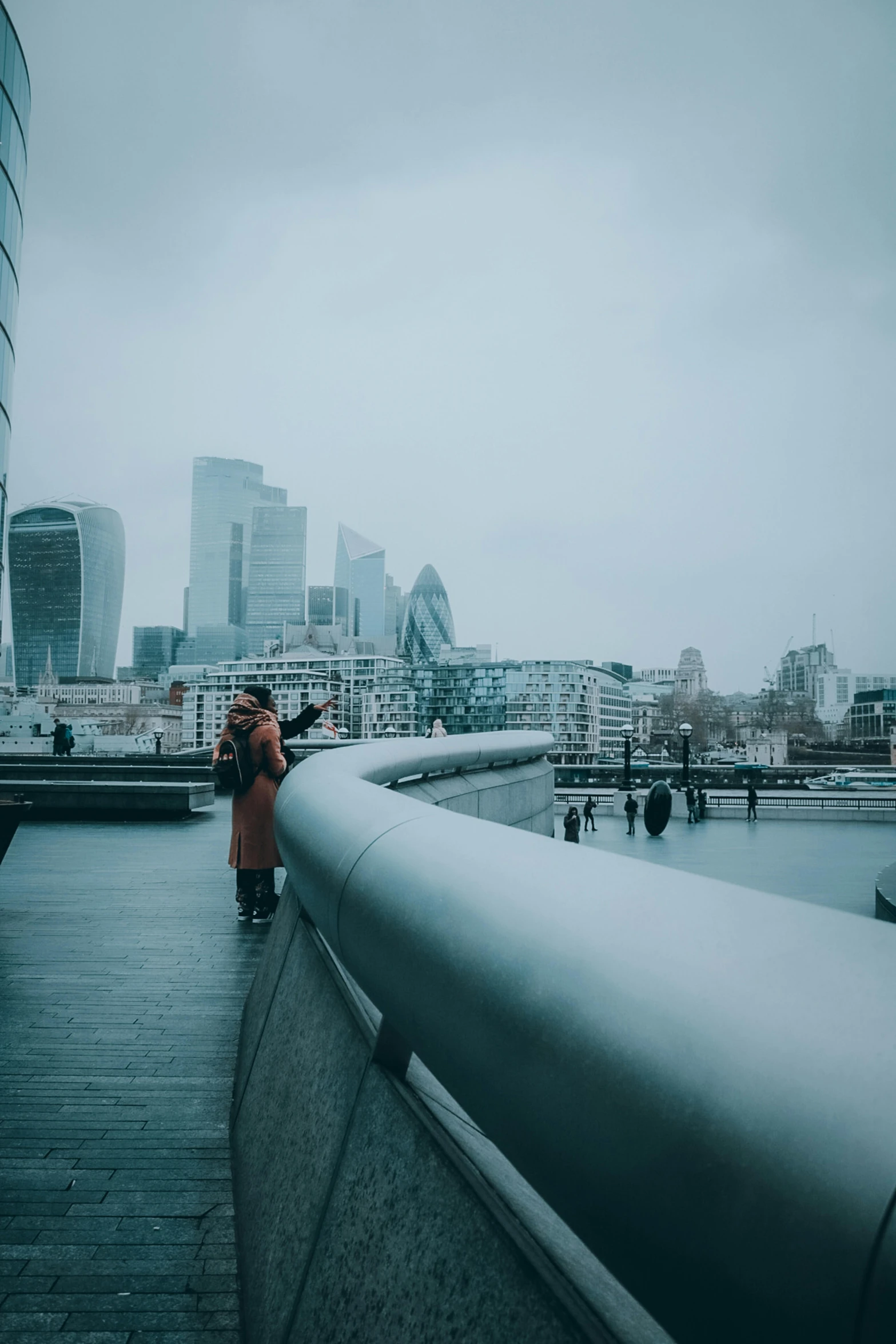 people walking on a bridge in a city