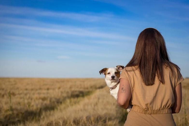 a person walking with a dog on their shoulder