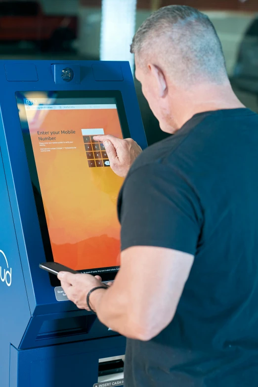 a man in black shirt next to a blue machine