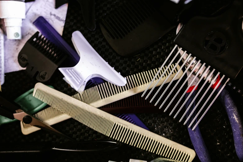 multiple different types of hairbrushs and combs on top of each other