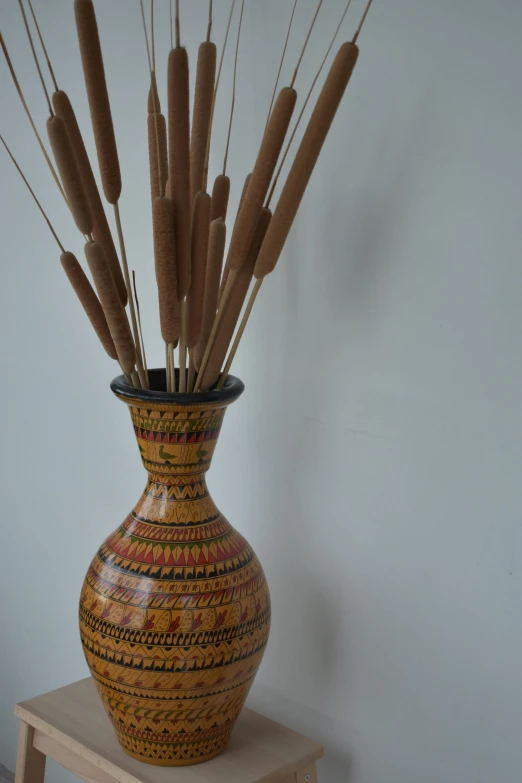 a close up of a vase with several sticks sticking out of it