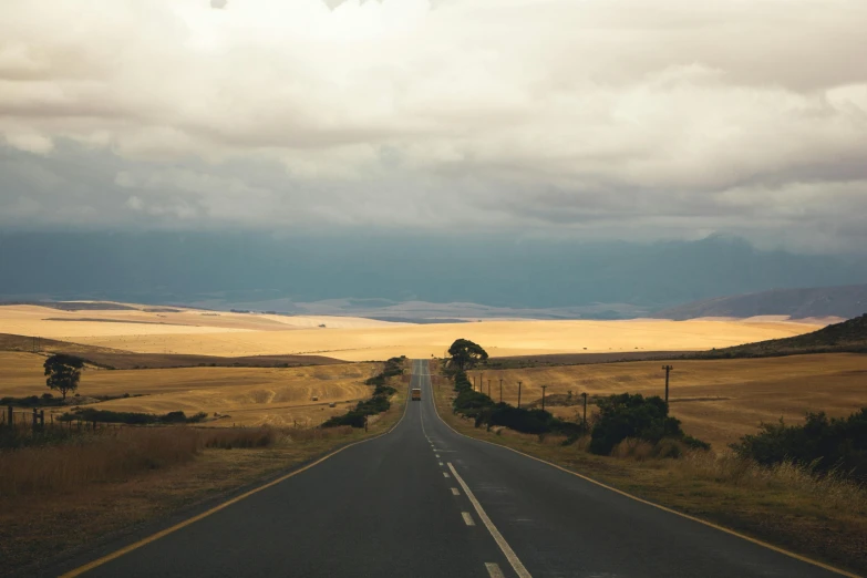 a country road in a desert on an overcast day