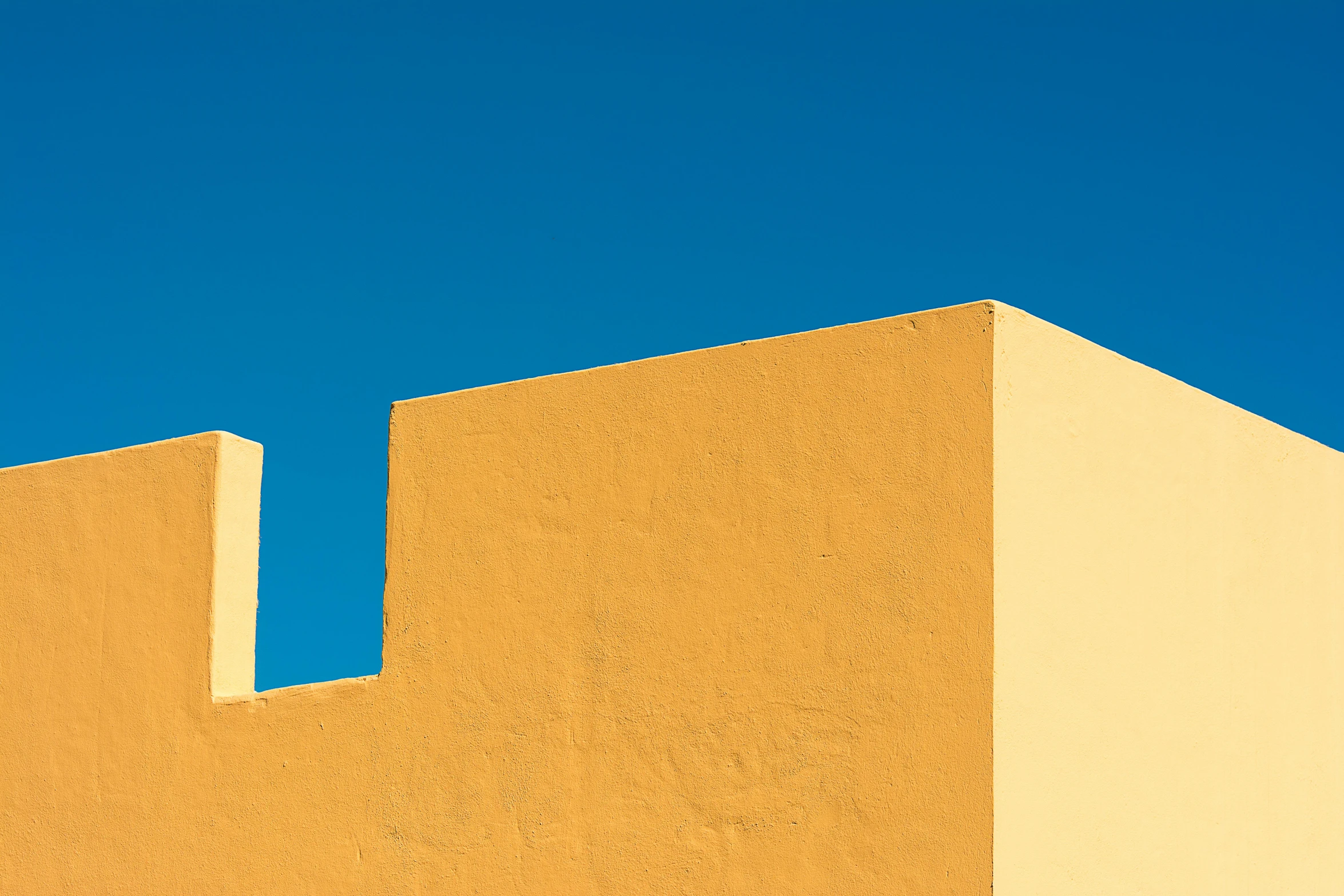 orange stucco building with light blue sky in background