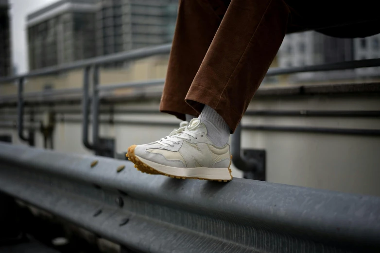 a person's white shoe standing on a metal rail