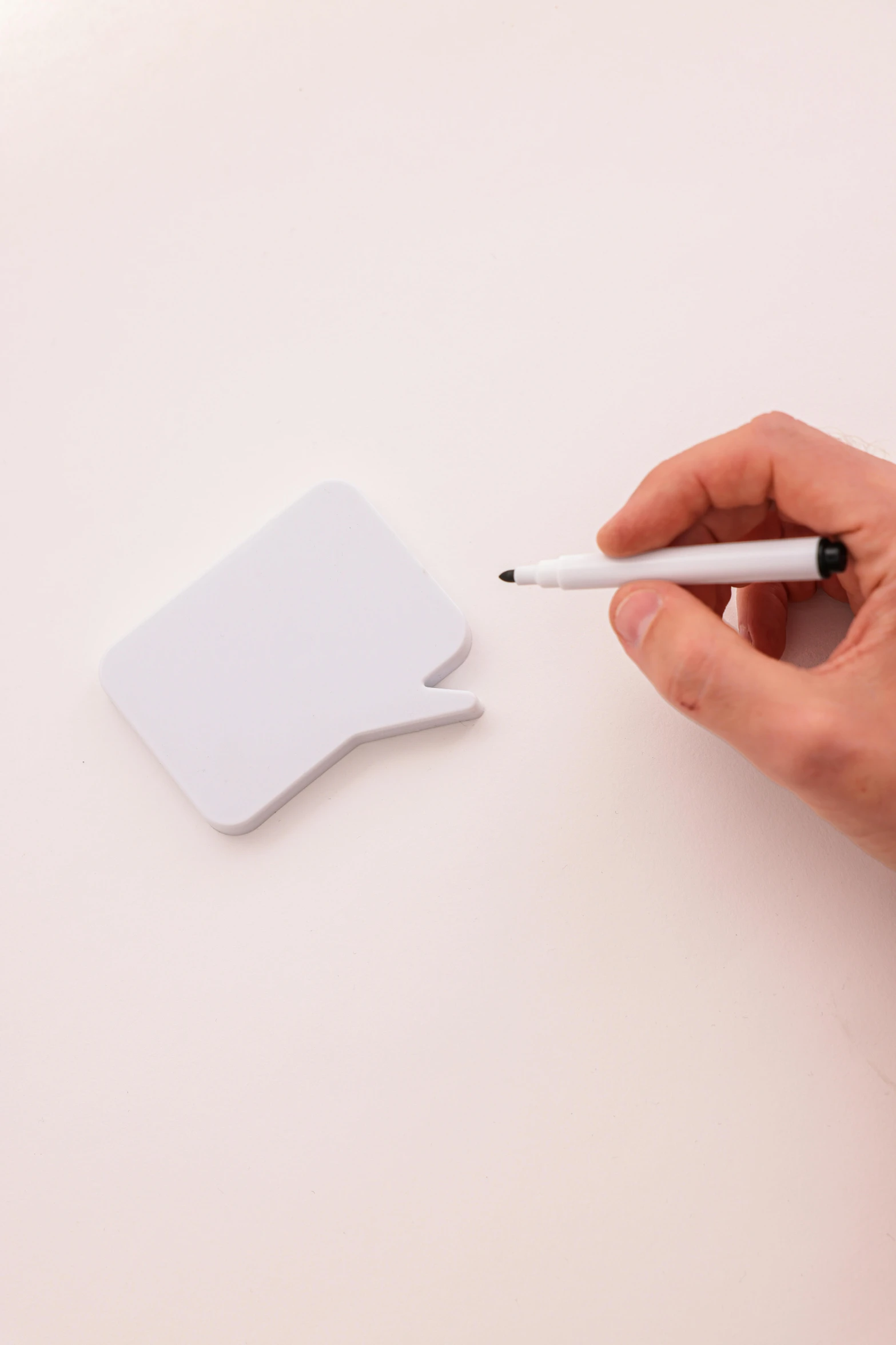 hand with a pen writes a question on an apple mouse