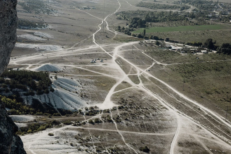 aerial view of an area with a long, sandy road and winding dirt trail