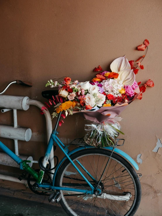 a bicycle sitting next to a building with flowers