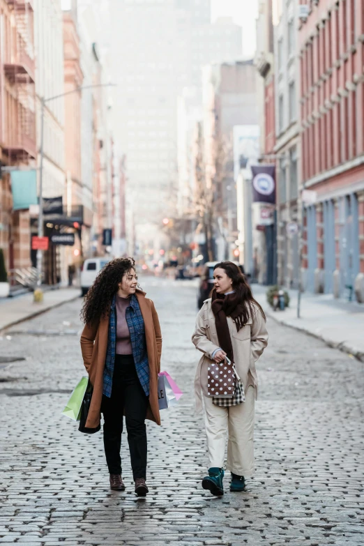 two women walk through an old brick street