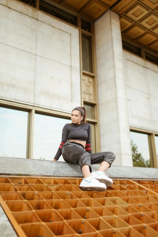a woman sitting on a ledge of an building