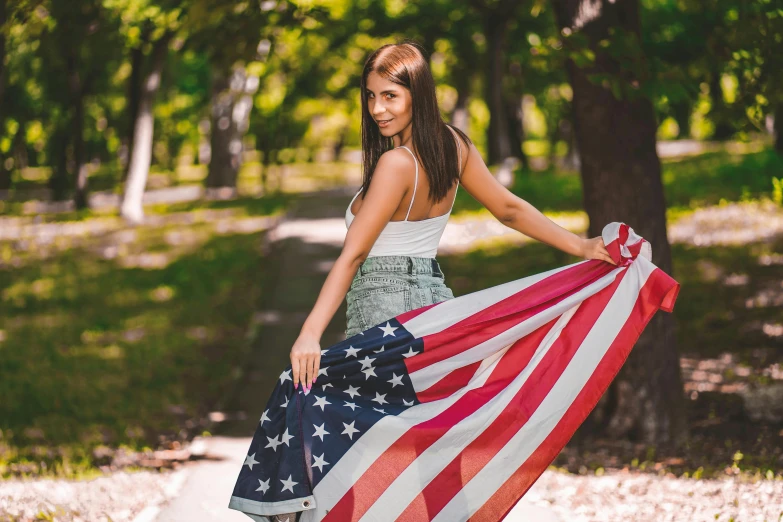 a beautiful young woman holding an american flag