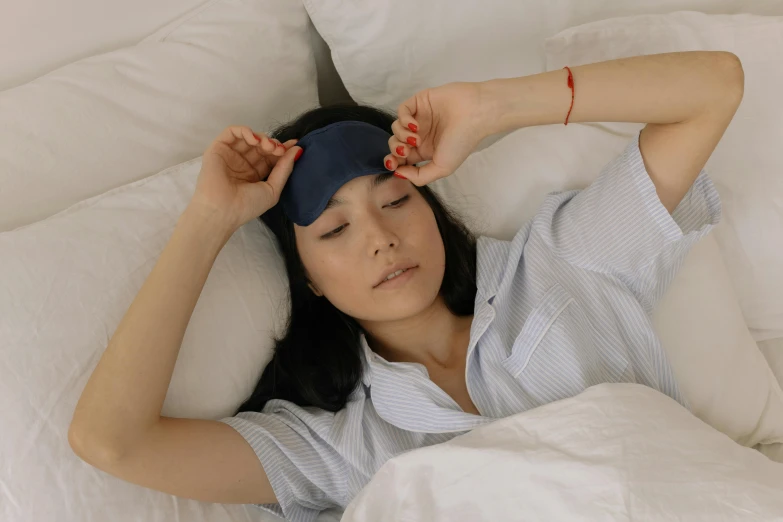 a woman laying down on top of a white bed