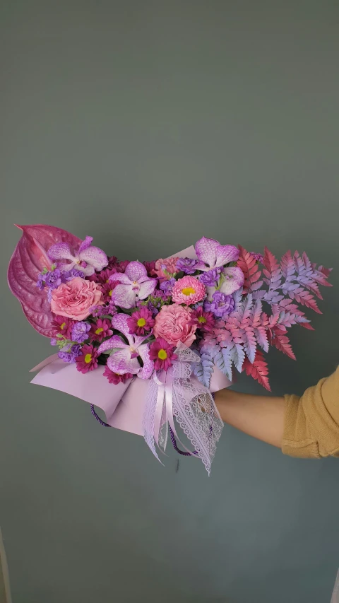 woman holding up some pretty flowers to show the large bouquet