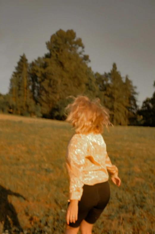 a little  standing in the grass with a frisbee