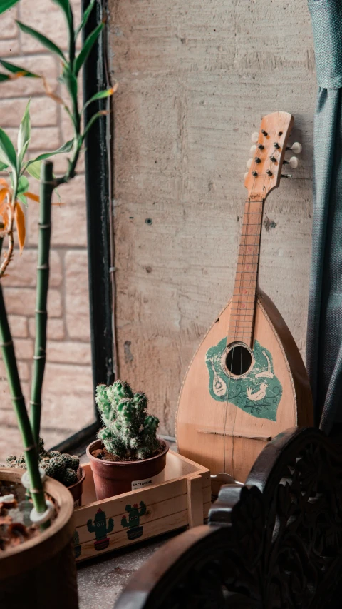 a guitar made out of wood sitting in a planter next to a window