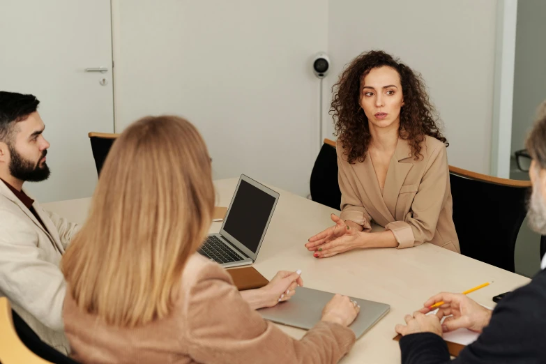 a woman talking to her colleagues while sitting in an office