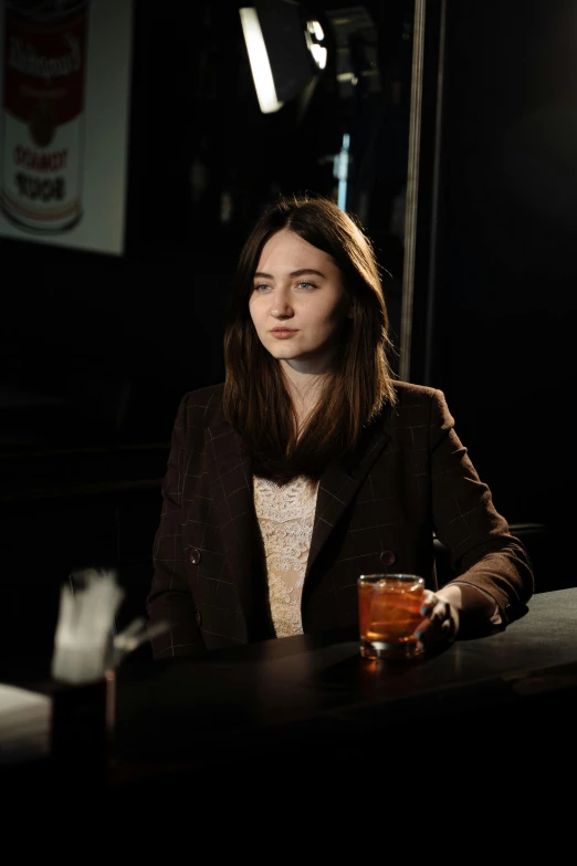 woman sitting at bar with alcohol in front of her