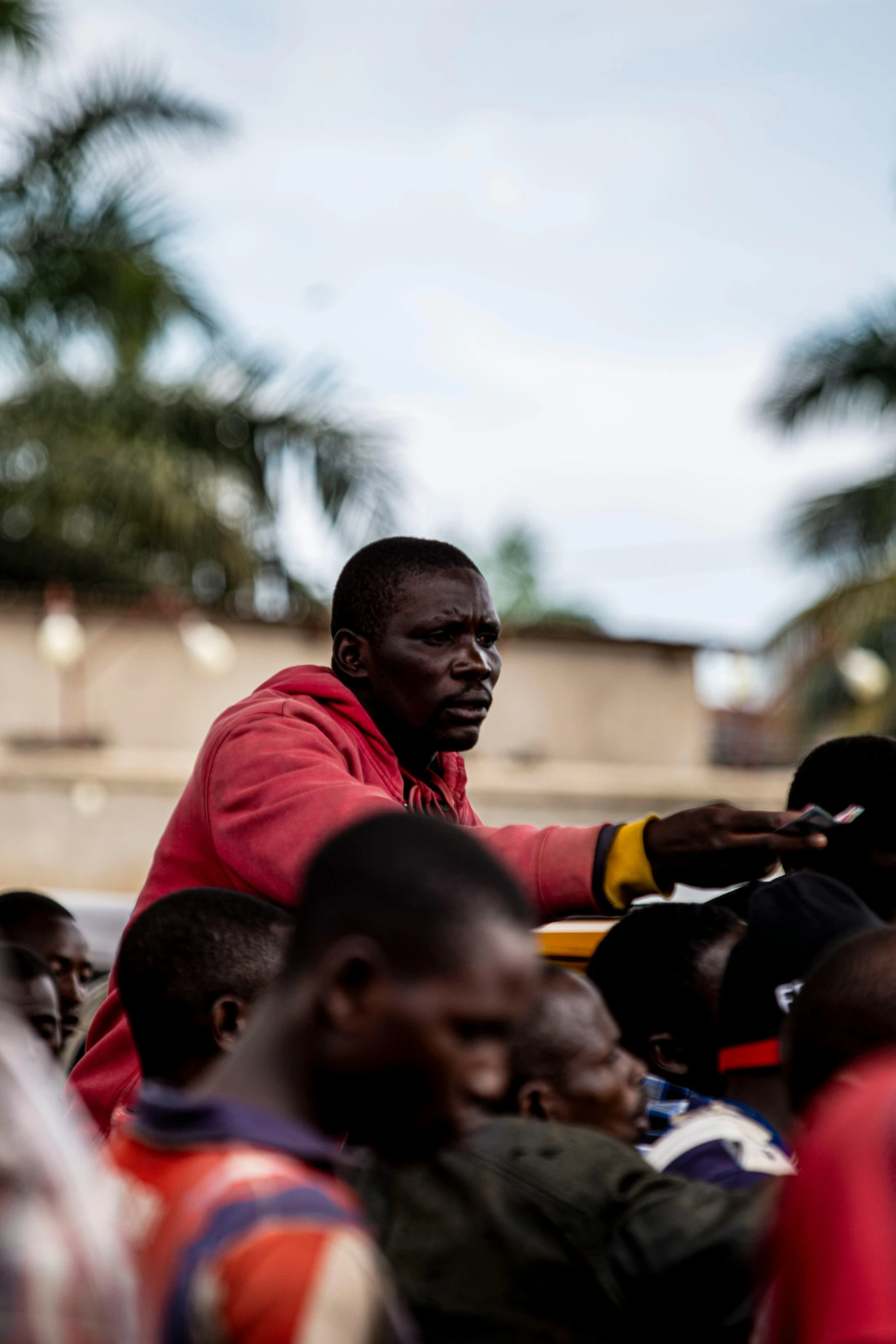 a man putting soing into his mouth while standing among people