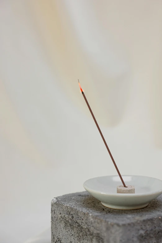 a stone table topped with a bowl filled with incense