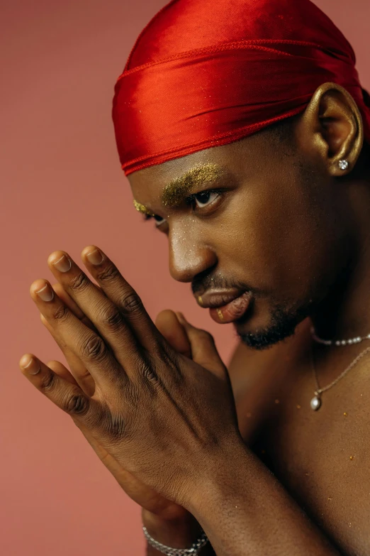 a man with his hands together while dressed in gold