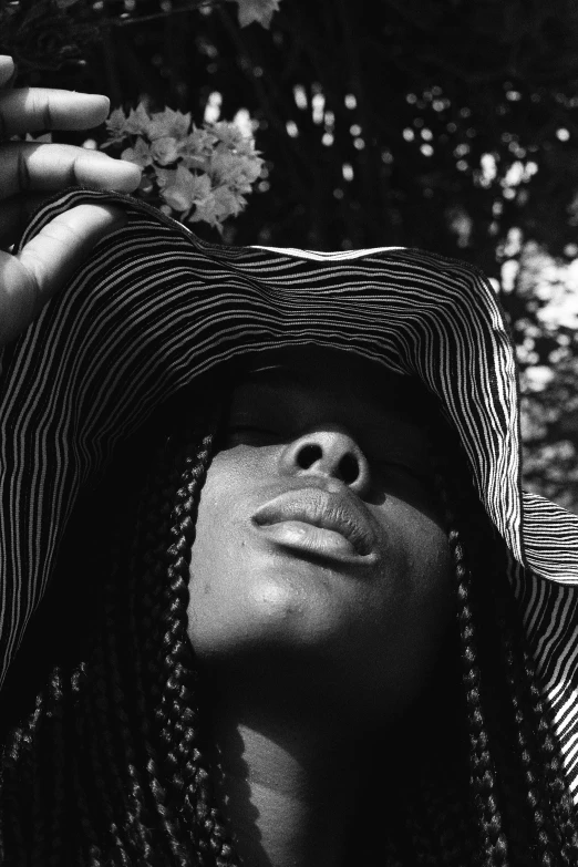 woman in hat looking at the camera with trees behind her