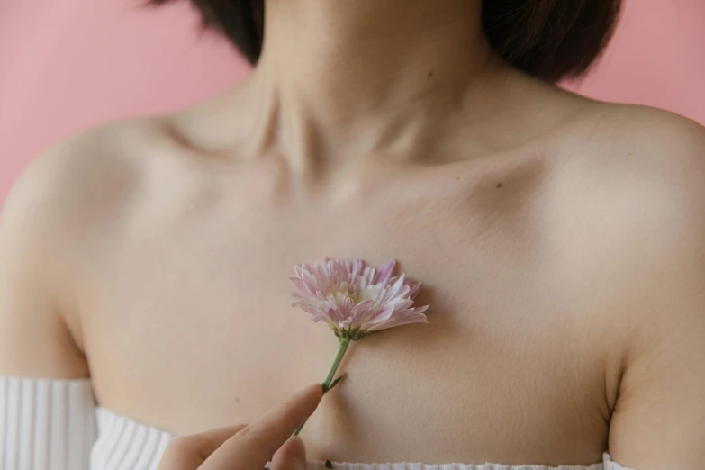 the top half of a woman with a pink flower