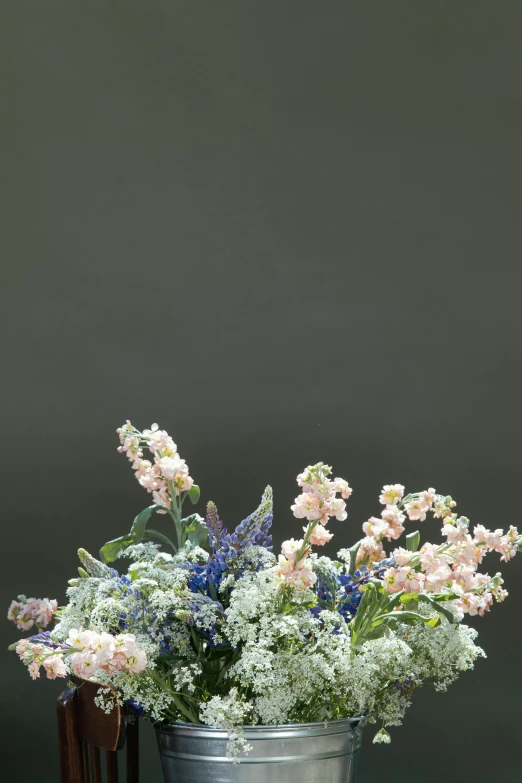 a metal pail filled with pink and white flowers