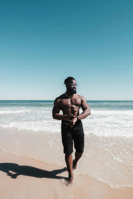 a black man running on the beach, wearing s